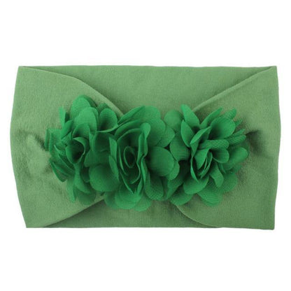 Top-down view of a baby girl's head with a comfortable, soft floral elastic headband.