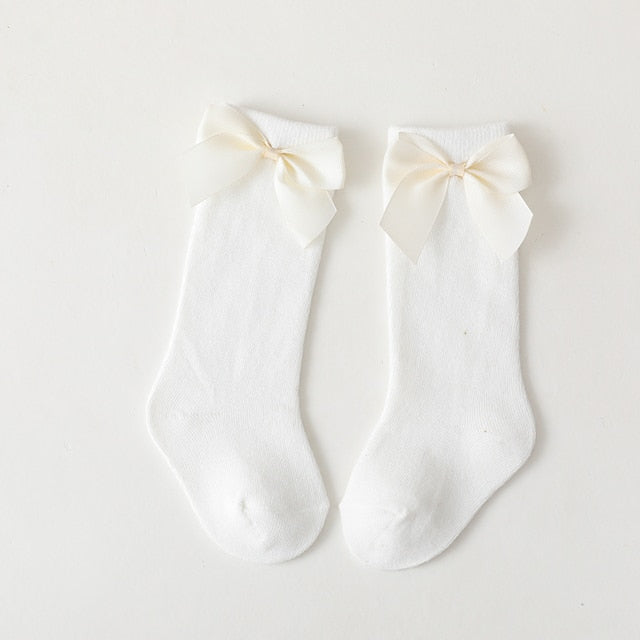 Spanish style baby knee-high socks in cream with elegant matching bows and ruffle