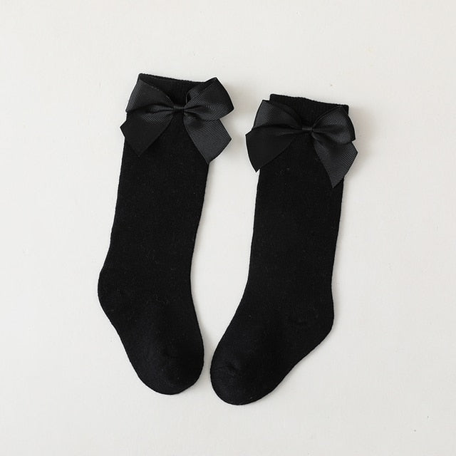 Adorable yellow knee-high socks for baby girls with contrasting white decorative bows