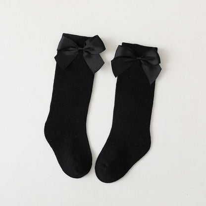 Adorable yellow knee-high socks for baby girls with contrasting white decorative bows