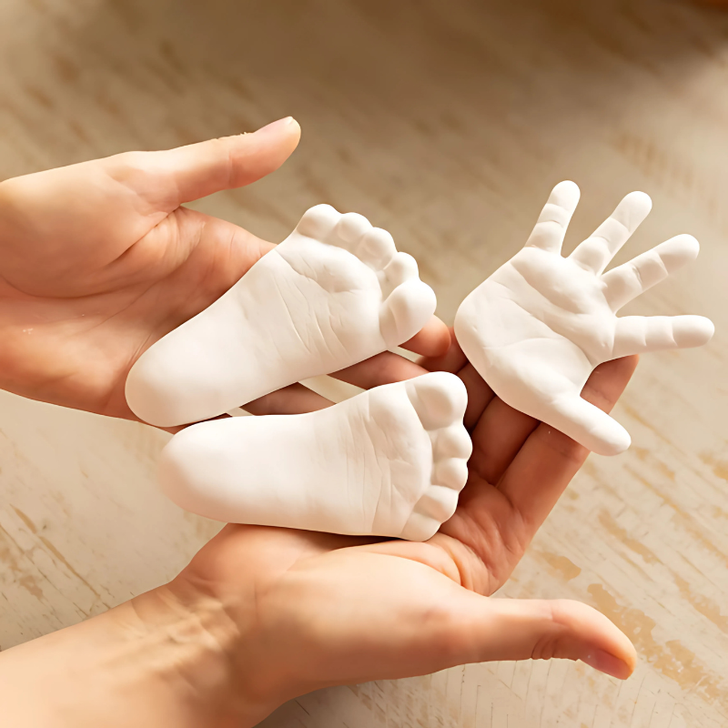 Baby Hand & Foot Print Casting Kit with a newborn's tiny hand and foot impressions displayed.