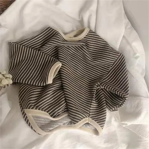 Detail of sleeve cuff on a kids' striped long sleeve t-shirt, snug and comfortable fit. 91 characters