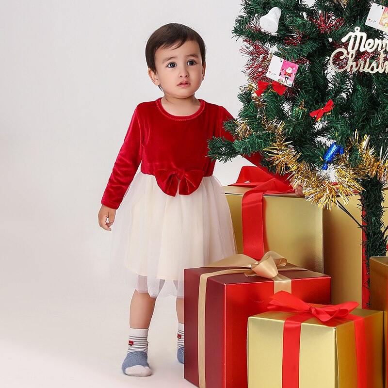 Close-up of a baby's red plaid outfit, featuring soft fabric and classic design for family.