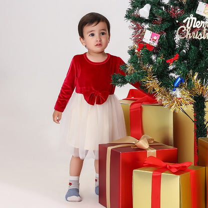 Close-up of a baby's red plaid outfit, featuring soft fabric and classic design for family.