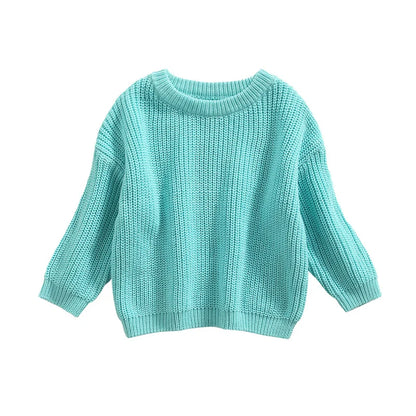Overhead shot of a baby in a cream knitted pullover, comfortable and casual baby clothes.