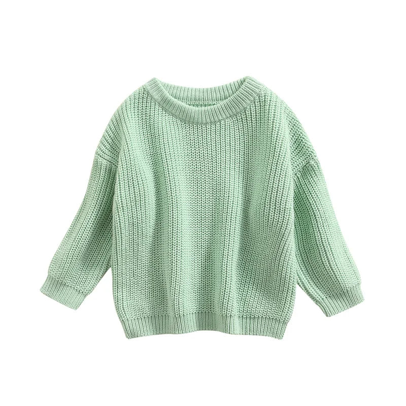 Baby sitting up wearing a soft cream knitted sweater, ideal for casual baby clothes.