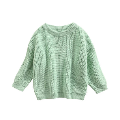 Baby sitting up wearing a soft cream knitted sweater, ideal for casual baby clothes.