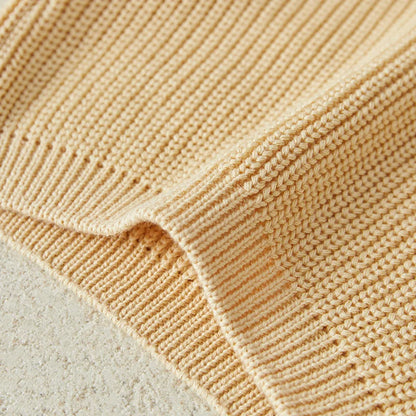 Baby wearing cream knitted long sleeve sweater, demonstrating comfortable toddler fashion.