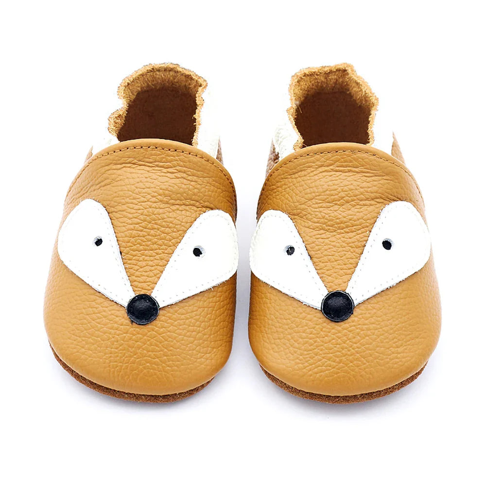Newborn baby leather moccasins in various earthy tones, arranged artfully