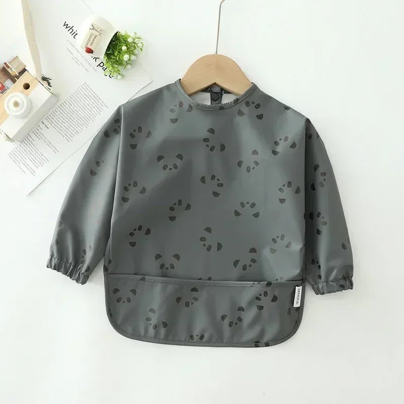Child painting while wearing a long sleeve waterproof art smock bib, protecting clothing