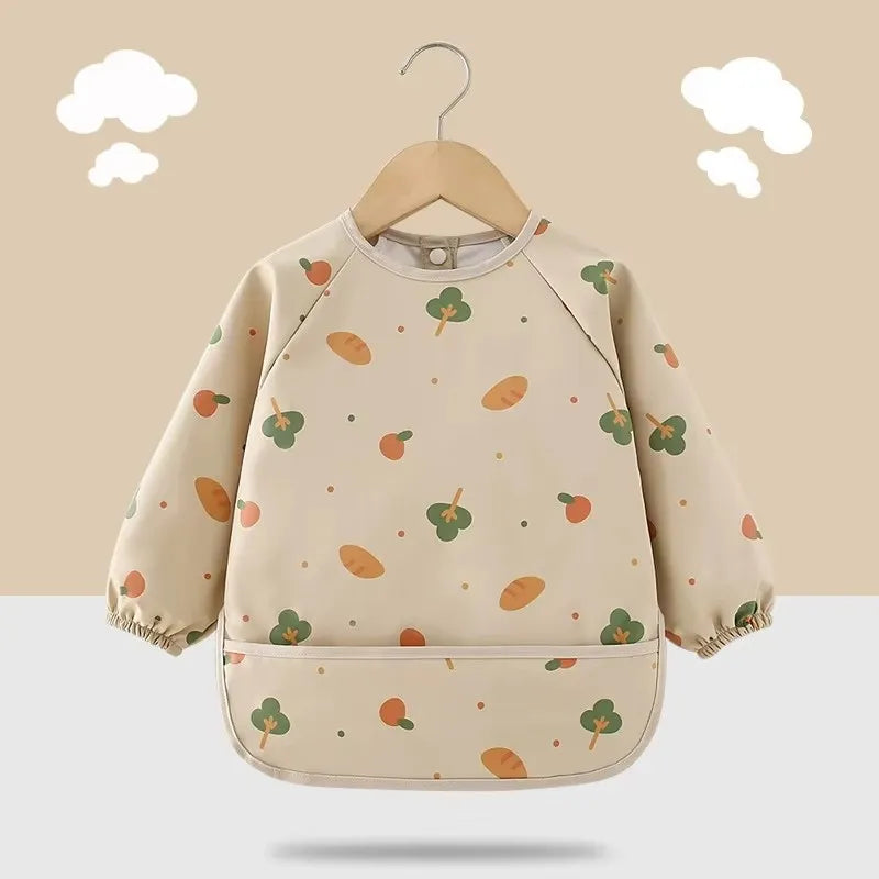 Parent easily wiping clean a long sleeve waterproof feeding bib after baby's meal