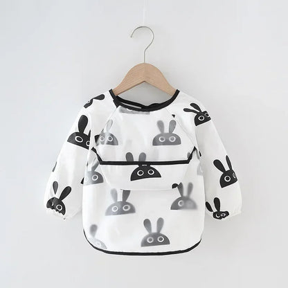 Toddler playing with playdough in a long sleeve waterproof bib, also suitable as an art smock