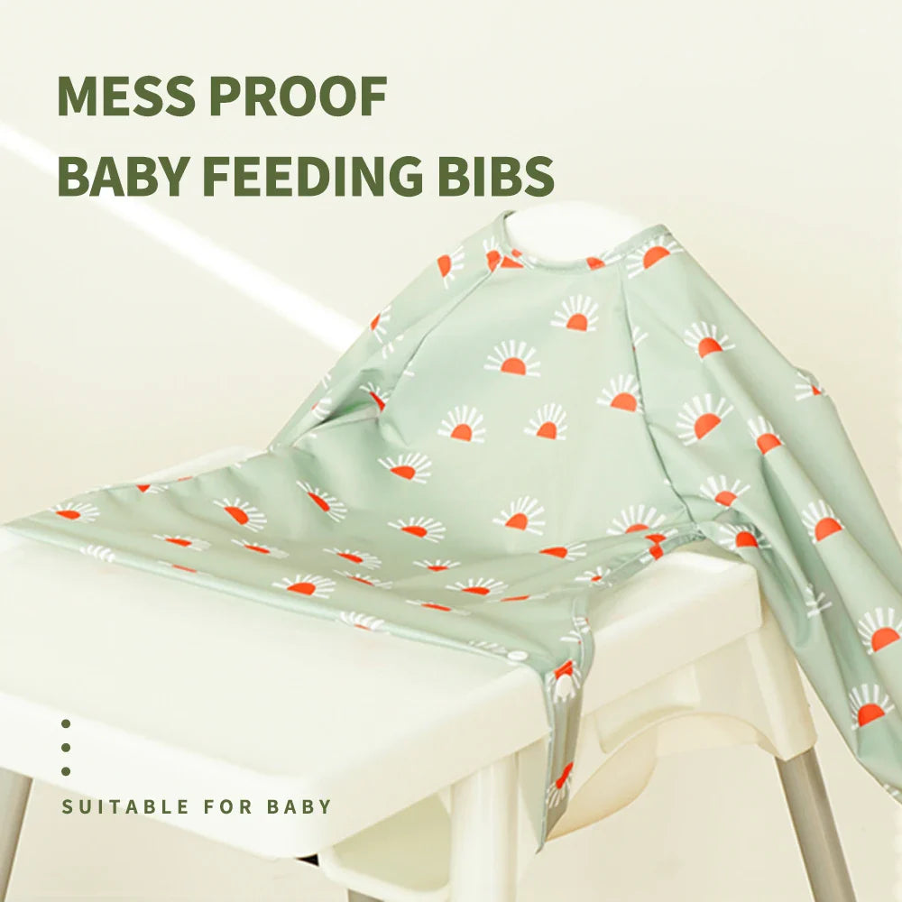 Toddler long sleeve feeding bib, green dinosaur pattern, with large catch-all pocket for easy cleaning