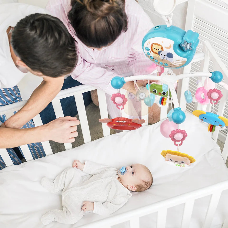 Overhead shot of a baby looking up at a musical mobile with a gentle projector glow