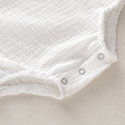 Infant sleeveless muslin jumpsuit with easy-changing snaps, comfortable cotton gauze baby outfit.