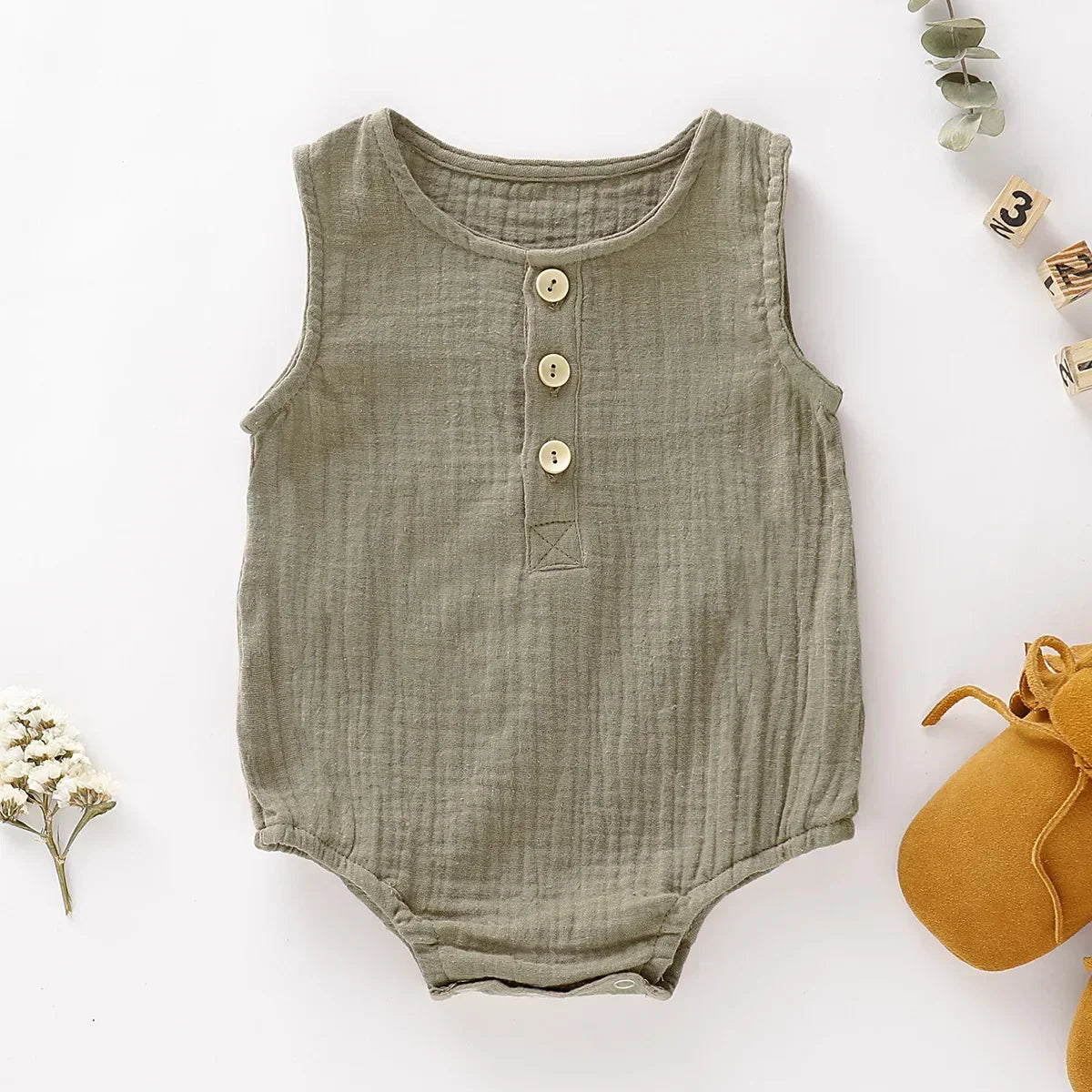 Cute newborn muslin romper, a practical sleeveless jumpsuit for baby's first summer adventures.