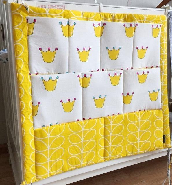 Functional crib organizer with multiple compartments for baby diapers, toys, and lotions.