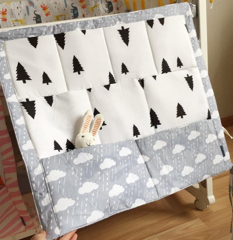 Multi-pocket baby organizer hanging on crib, ideal for diaper caddy and toy storage.