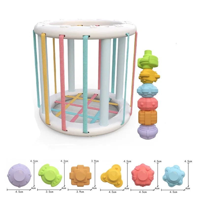 Child grasping a shape from the Baby Rainbow Shape Sorter, fine motor skill practice