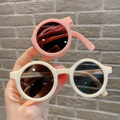 Cute baby foldable round sunglasses with a bright red frame, offering essential UV protection