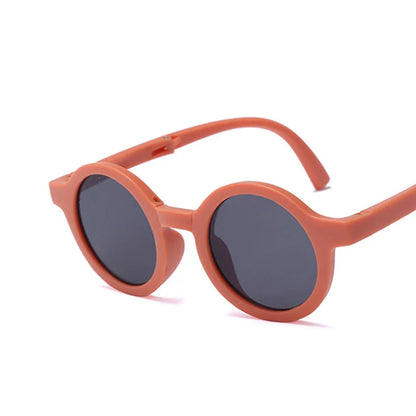 Close-up of foldable retro round baby sunglasses showing hinge detail and UV protective lens