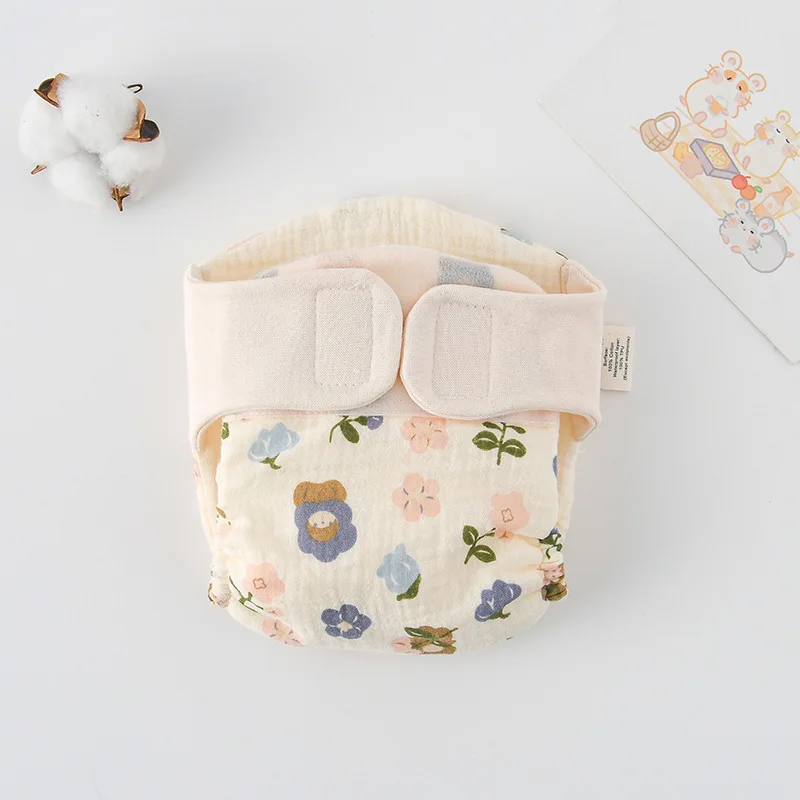 Stack of folded reusable cloth training pants with a playful design, ready for use