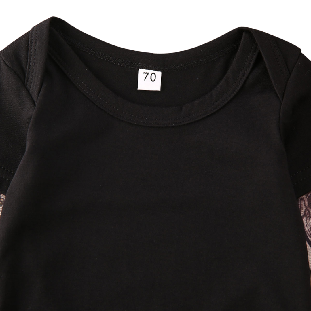 Two children, a baby in a romper and a toddler in a t-shirt, both with rose tattoo print outfits.