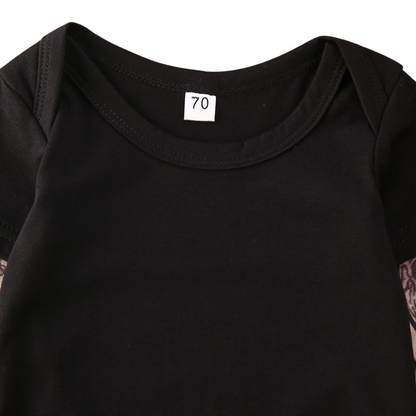 Two children, a baby in a romper and a toddler in a t-shirt, both with rose tattoo print outfits.