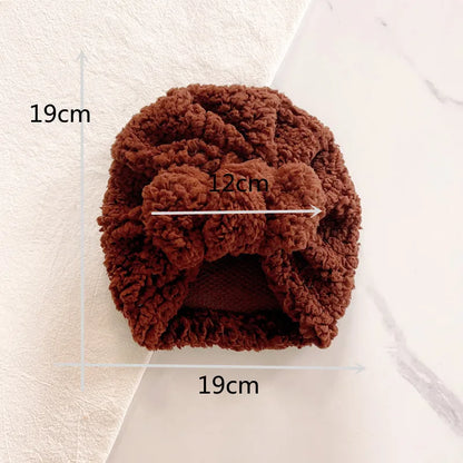 Close-up of a white knitted beanie hat, showing intricate soft knit texture, baby winter essential.