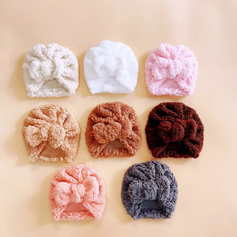 A cute baby wearing a cozy knitted beanie hat, smiling, showing warmth and comfort.