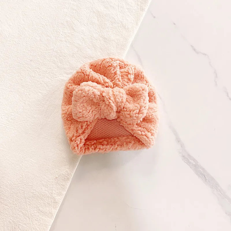 Infant headwear: a durable green knitted beanie hat, designed for winter protection and comfort.