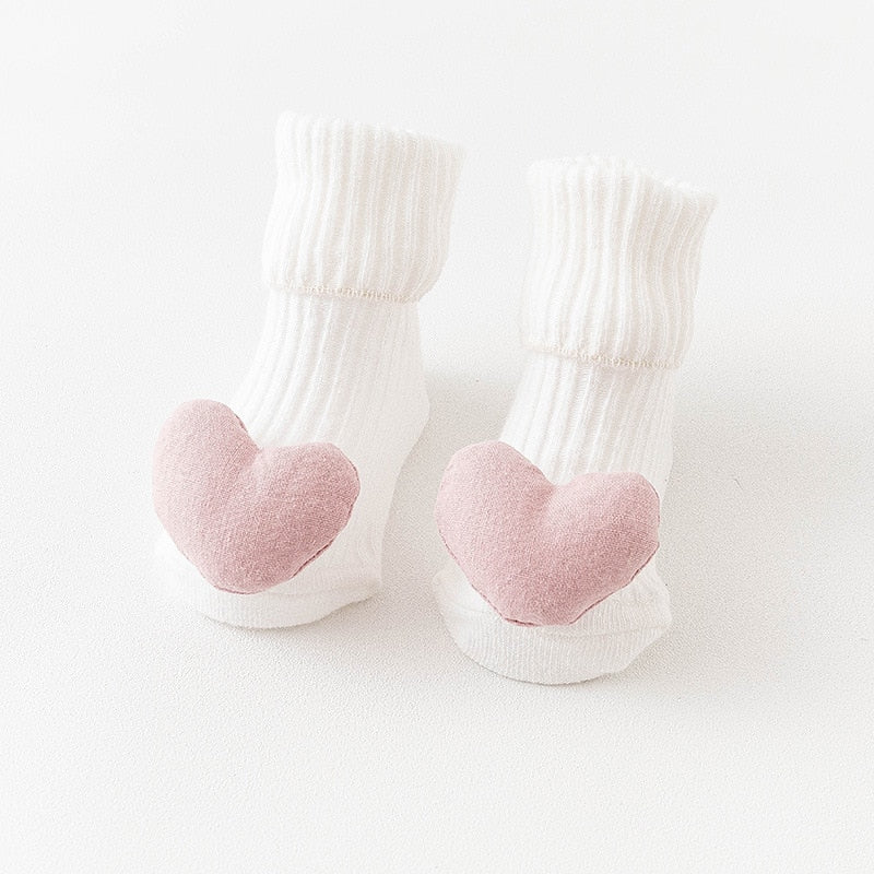 Close-up of a baby's anti-slip long sock with a friendly animal face design and grippy sole.