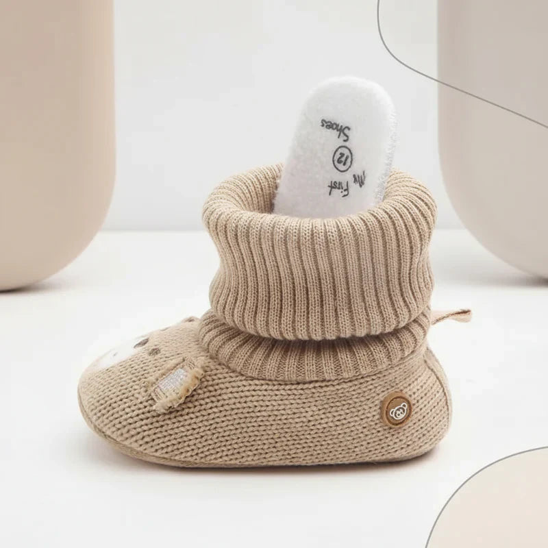Cute pink baby winter booties with a plush lining, great for keeping tiny feet warm.