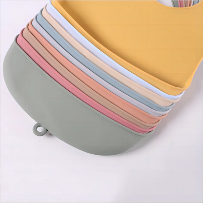 Close-up of pink waterproof silicone baby bib, showing soft texture & crumb catcher pocket