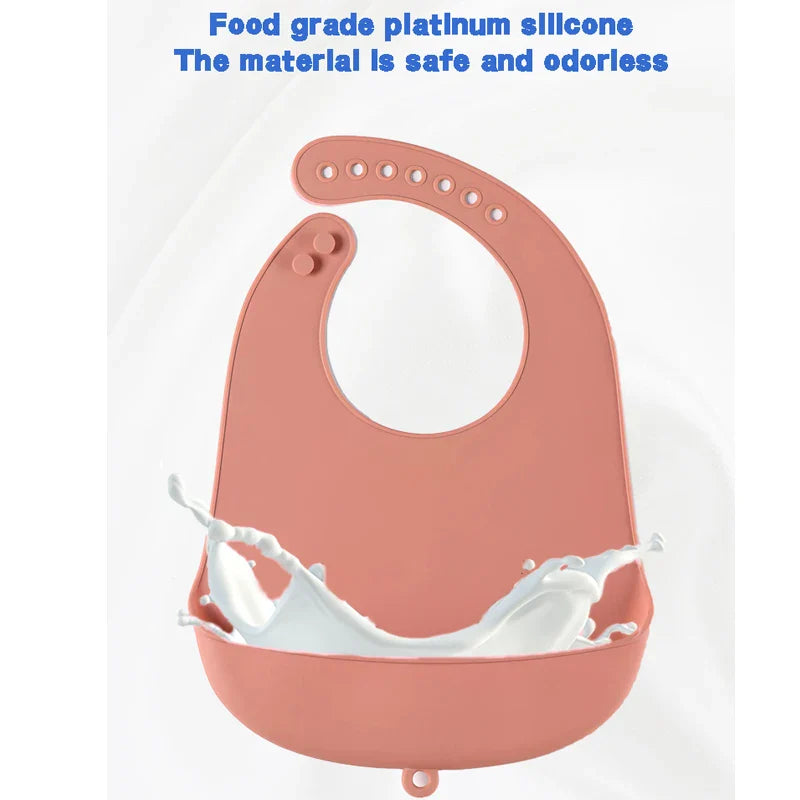 Baby enjoying solids wearing a waterproof silicone bib with deep food catcher pocket