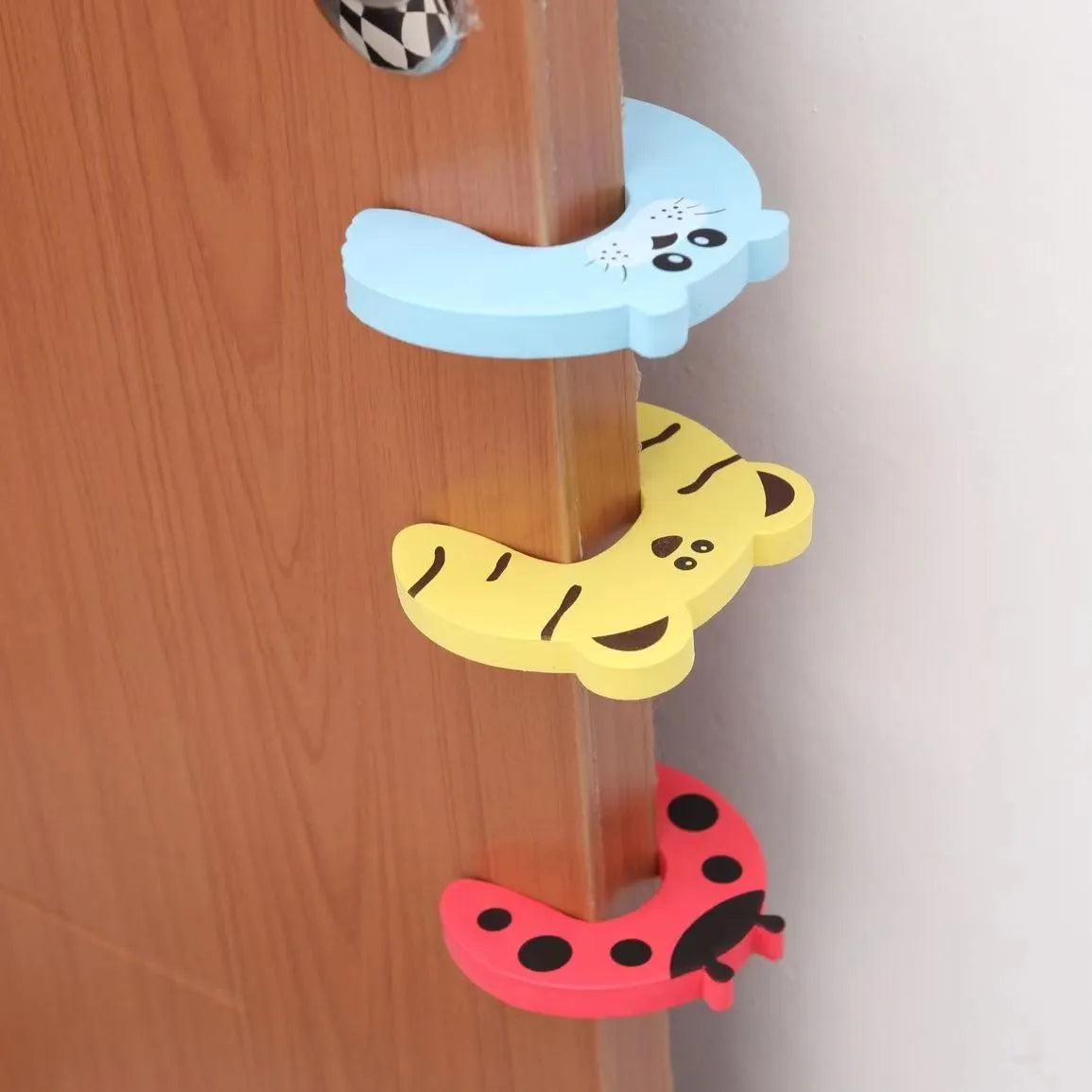 Demonstration of a baby safety cabinet lock in use, securing a kitchen cabinet door.