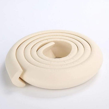 Close-up of white foam baby safety corner protector installed on a table edge.