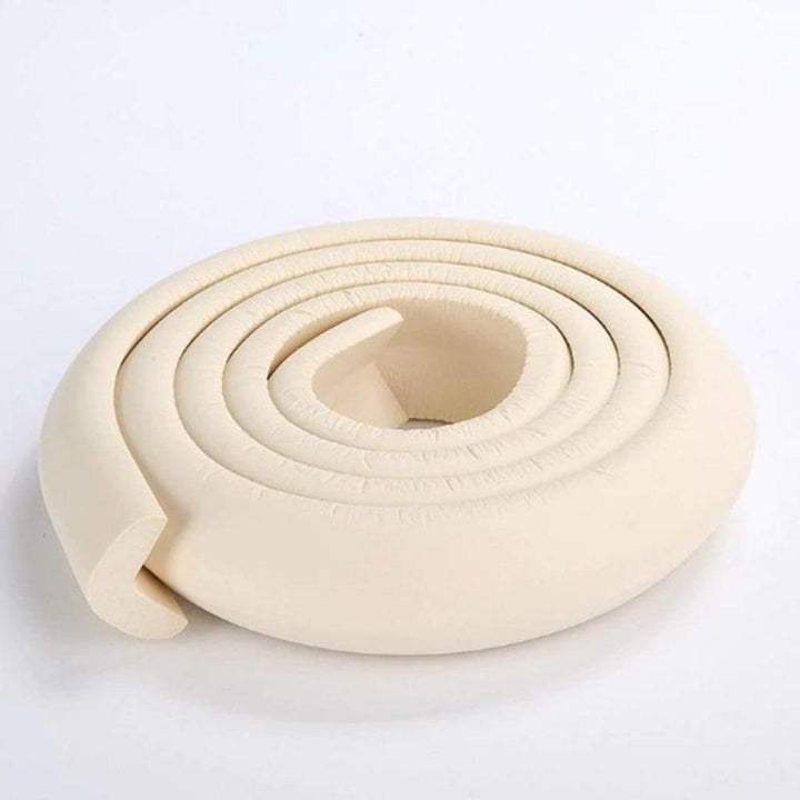 Close-up of white foam baby safety corner protector installed on a table edge.
