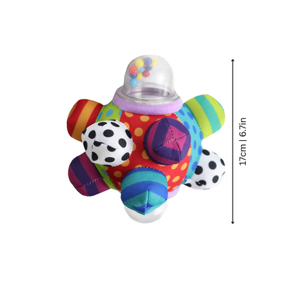 Close-up of a baby grasping a soft, colorful sensory rattle toy, promoting infant developmental skills