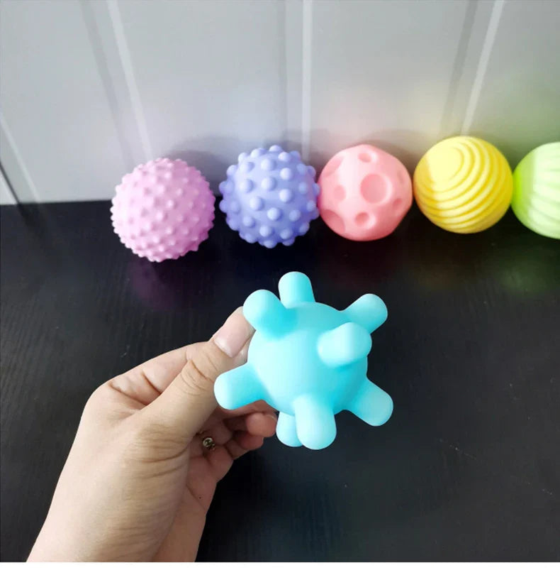 Child reaching for a textured rubber grip ball, making bathtime fun and engaging