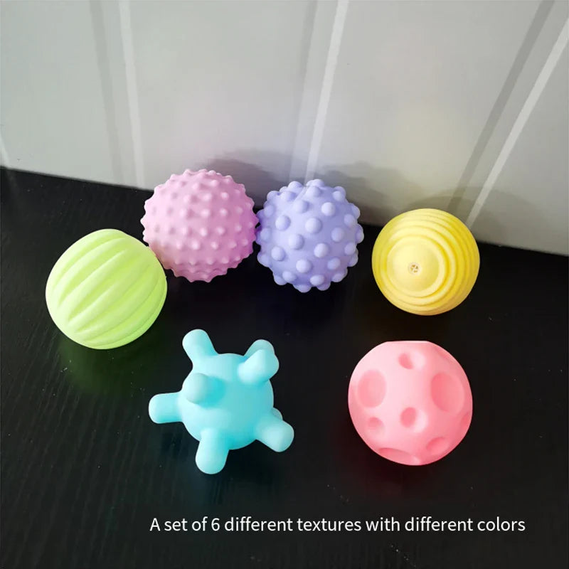 Hands of a child playing with a vibrant sensory grip ball during bathtime fun