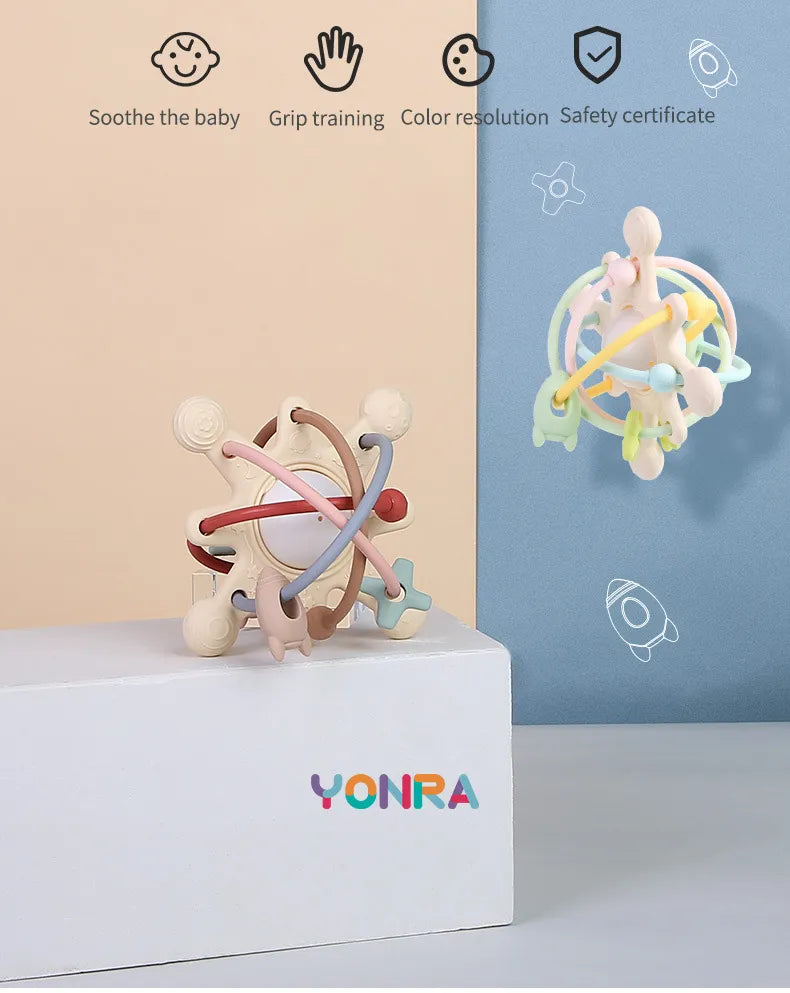 Hand holding a baby sensory teether ball toy with rattle, showcasing its design