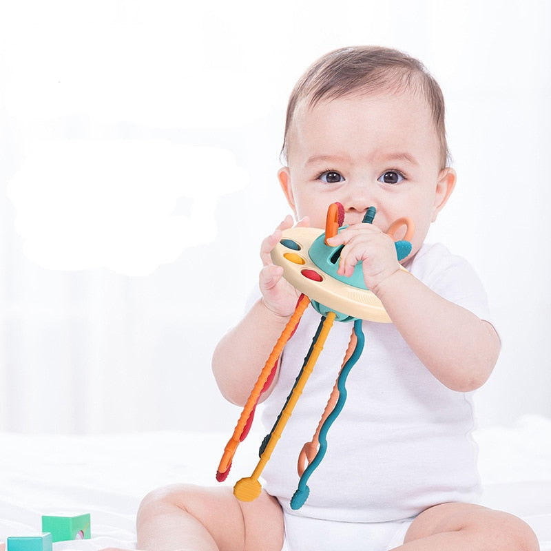 Close-up of a baby's hand grasping the flexible tubes of the UFO sensory activity toy
