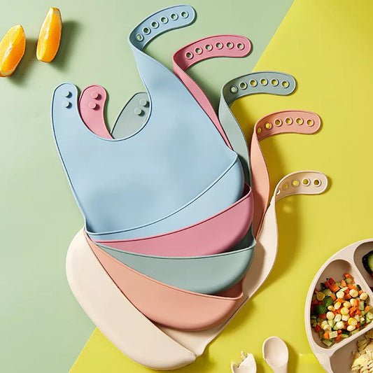 Baby silicone bib, adjustable snaps, solid pink, waterproof, for mess-free meals.