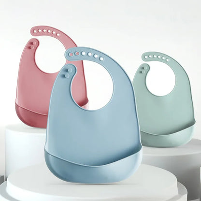 Easy-clean toddler silicone bib, solid color, with secure, adjustable snaps.