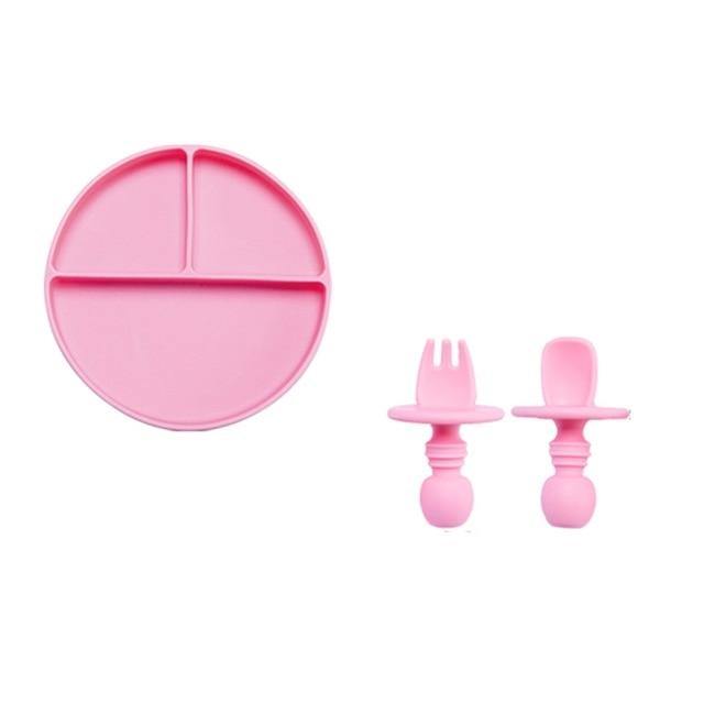 Collection of colorful baby silicone divided plates with spoons and forks for children's mealtime