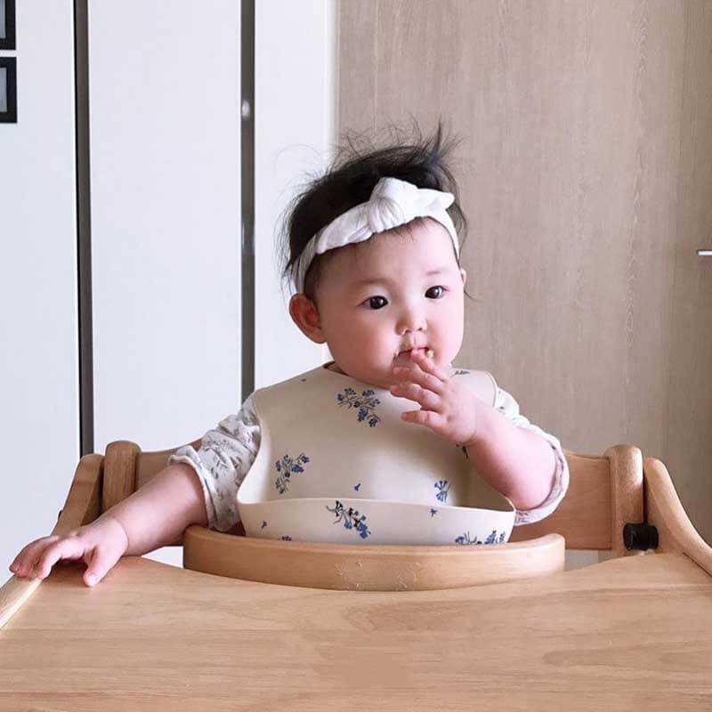 Close-up of pink silicone baby bib with deep food catcher pocket, ideal for infant mealtime