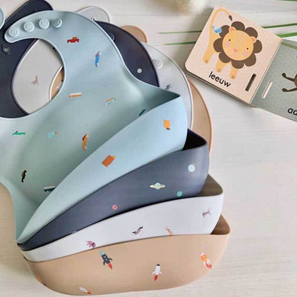 Toddler wearing a soft green silicone food catcher bib, showing the comfortable and secure fit