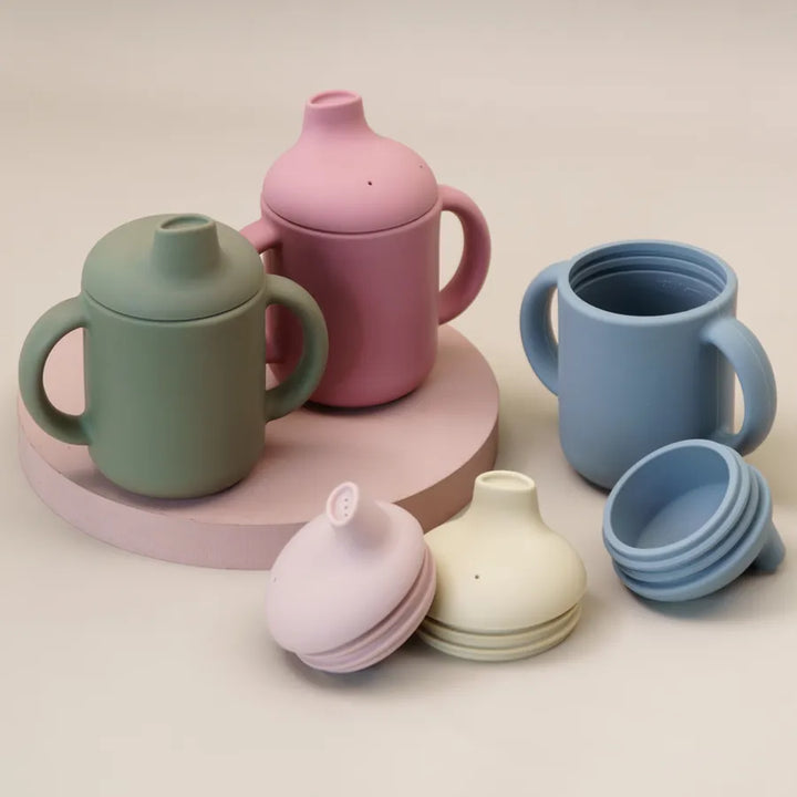 Soft silicone baby training cup with ergonomic handles for a comfortable, secure grip.