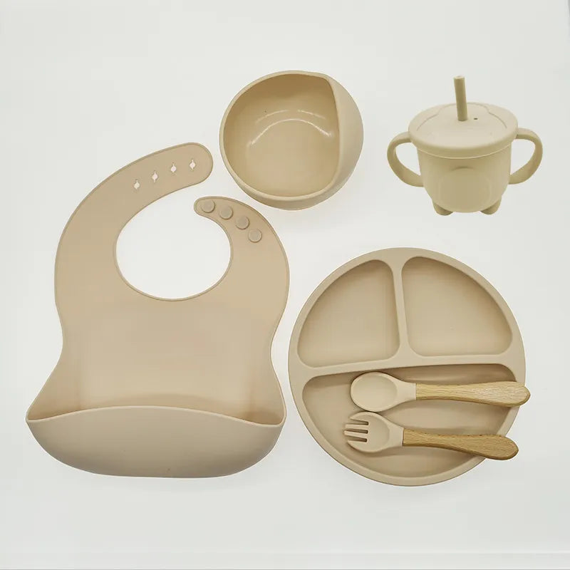 Practical baby silicone feeding solution: suction bowl, plate, bib, & soft-tip spoon for toddlers.